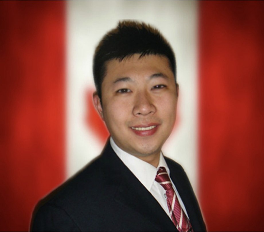 Portrait of Shengbo Yu in a suit, in front of the Canadian flag